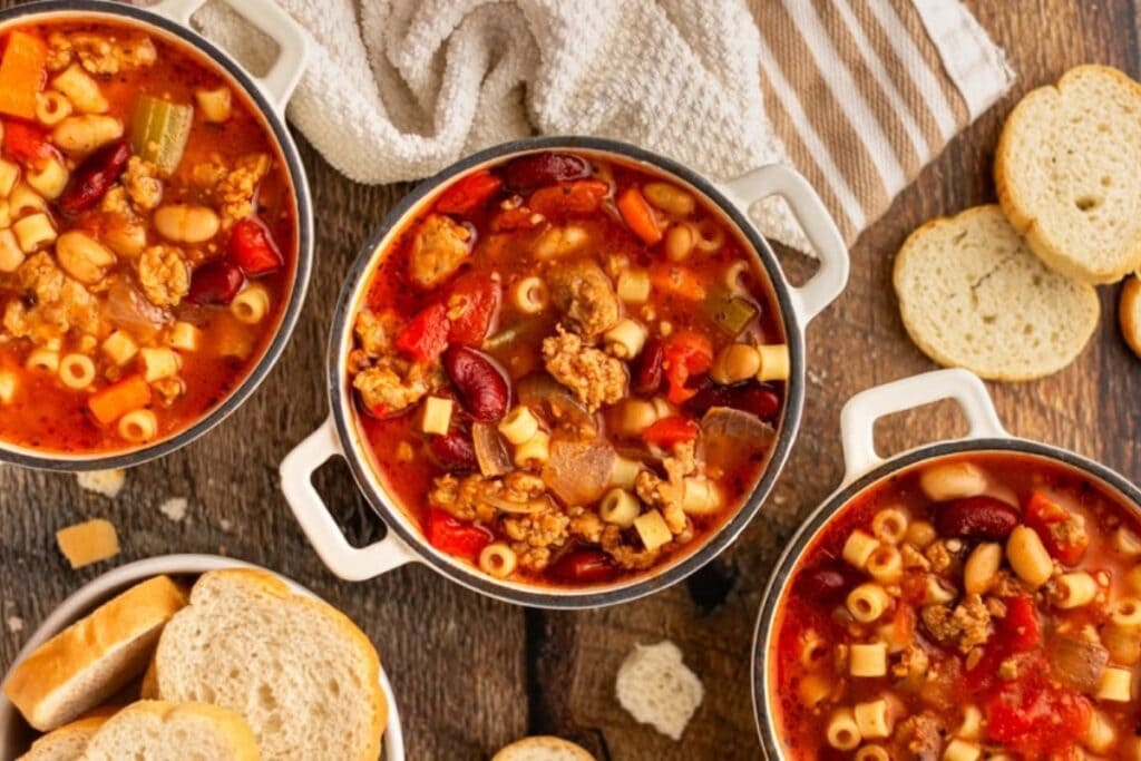 Pasta e fagioli soup in bowls with bread on the side.