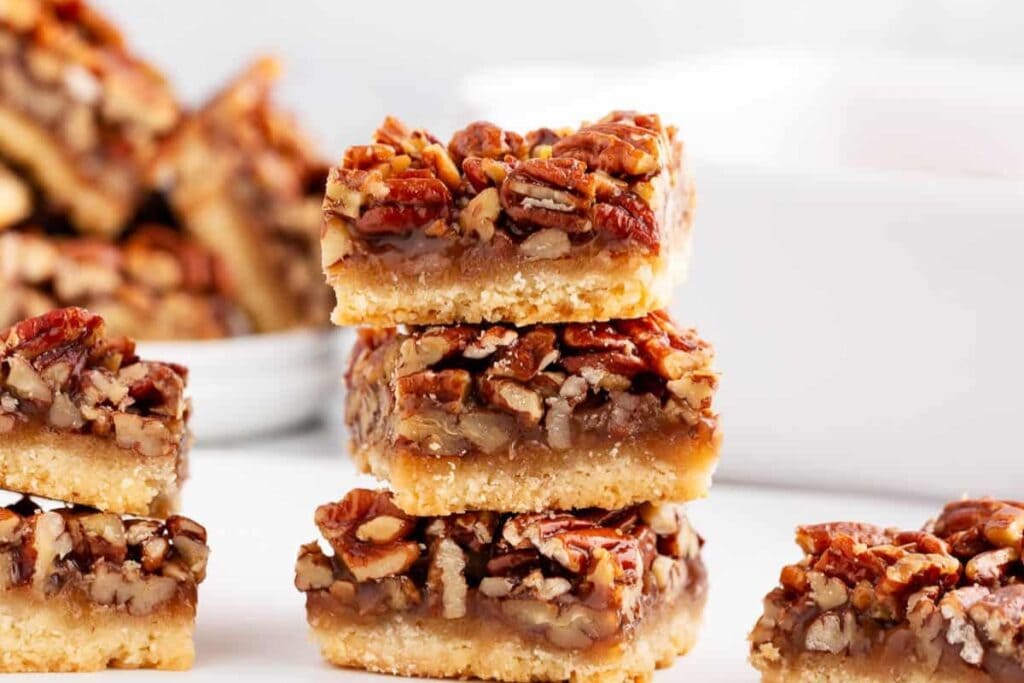 Stacked pecan pie bars with gooey nut filling and flaky crust.