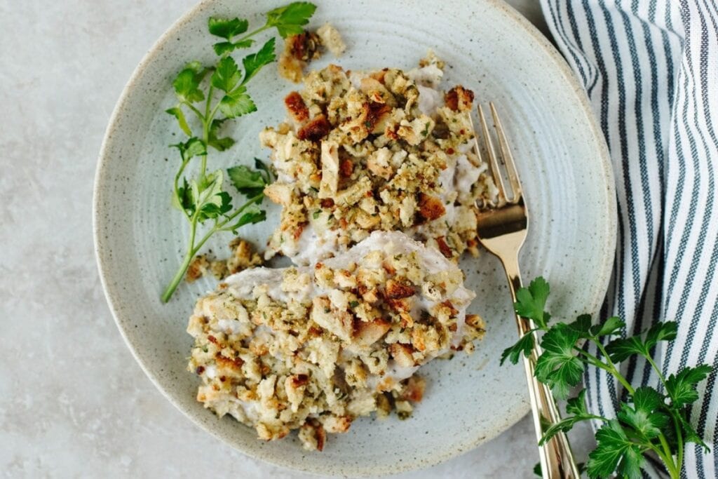 Pork chops and stuffing on a plate with a fork on the side.