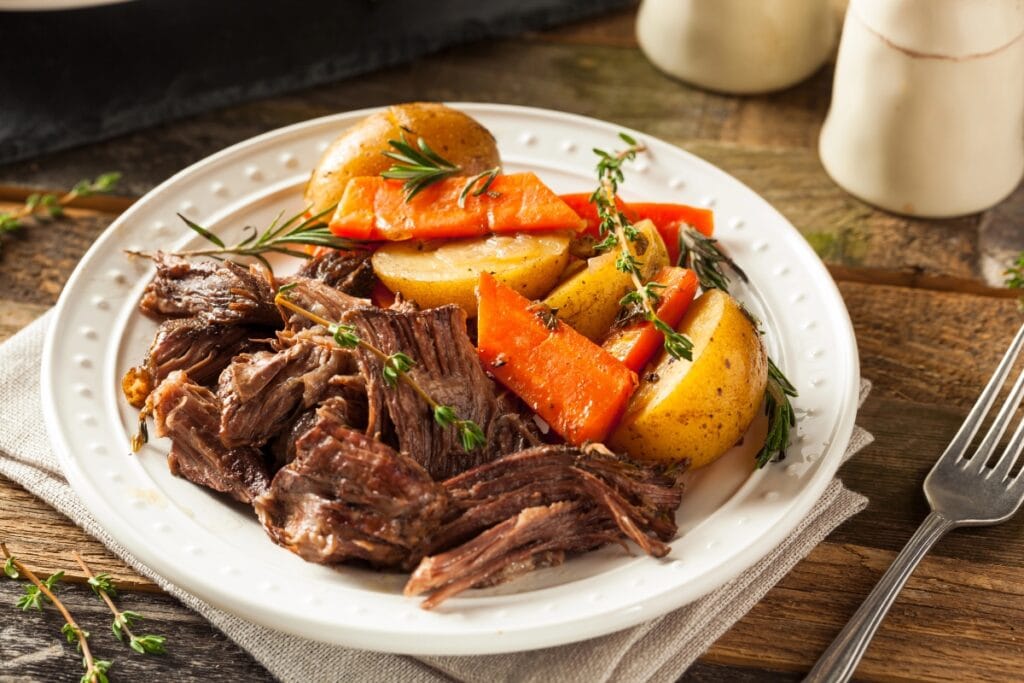 Pot roast served on a plate with tender beef and vegetables.