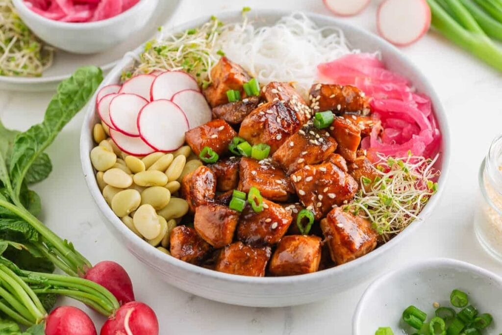 Salmon served with rice and vegetables in a bowl.