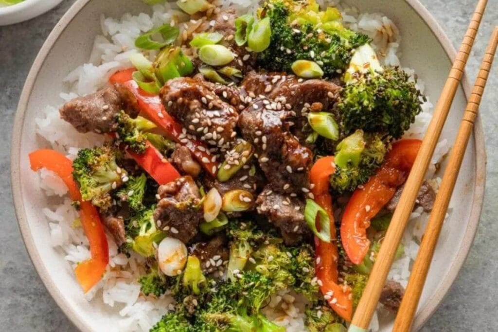 Beef and broccoli with rice on a plate.