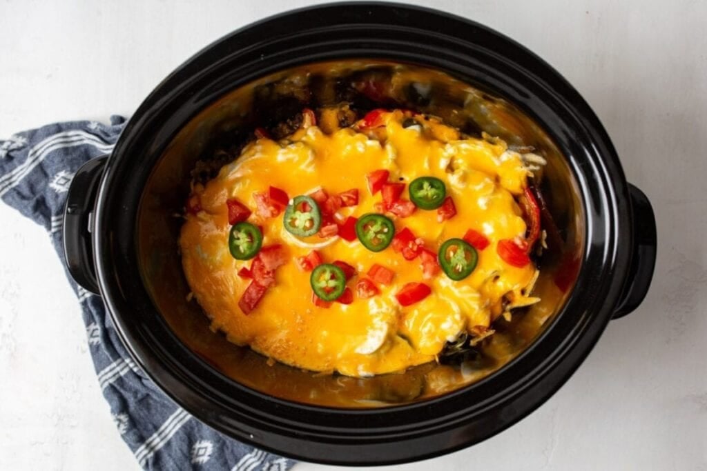 John Wayne casserole with cheese and jalapeños in a slow cooker.