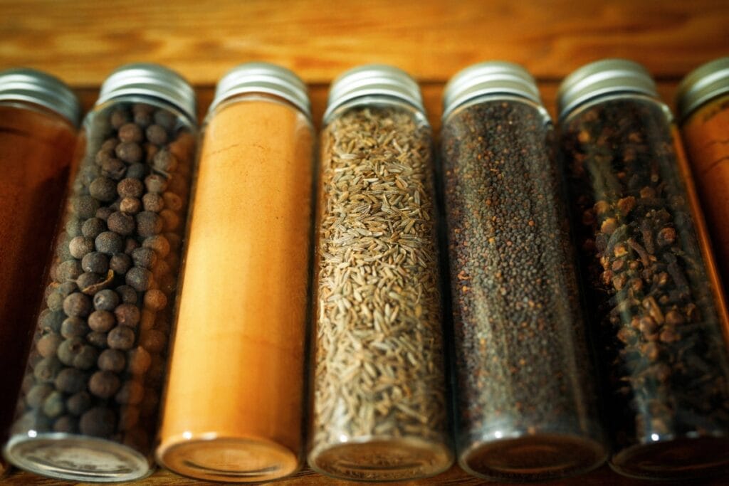 Assorted spices in lidded container on wooden table.