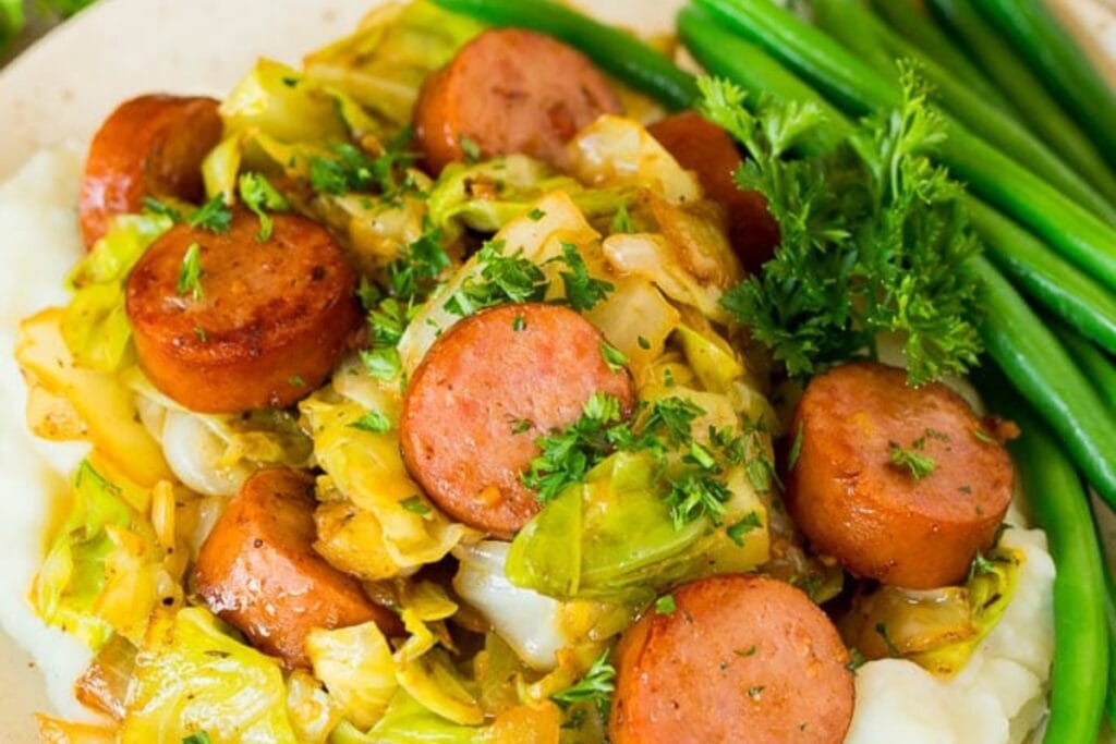 Teriyaki cabbage and sausage served on a plate with green beans on the side.