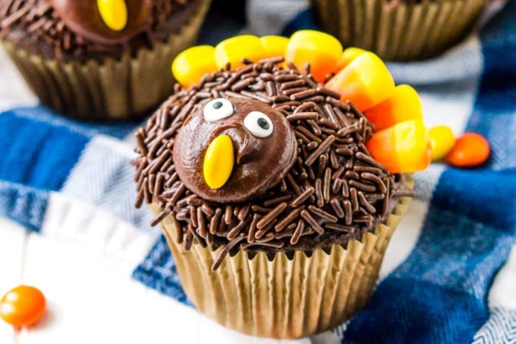 Close-up of turkey cupcakes with frosting and candy corn feathers.