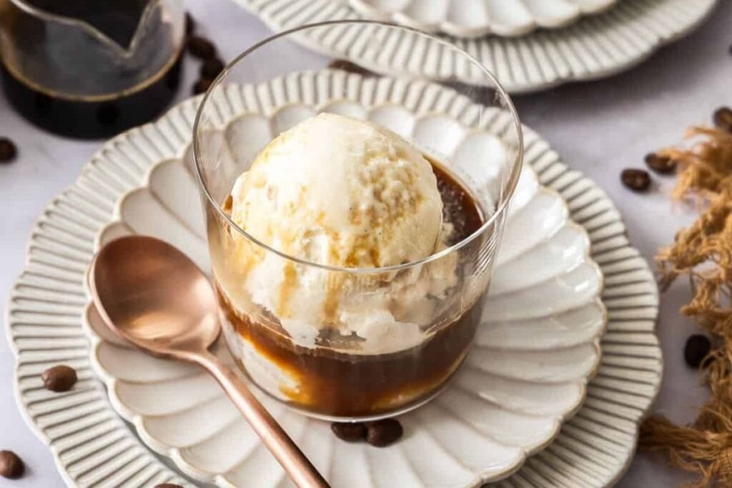 Affogato with a scoop of ice cream in a glass on a plate.