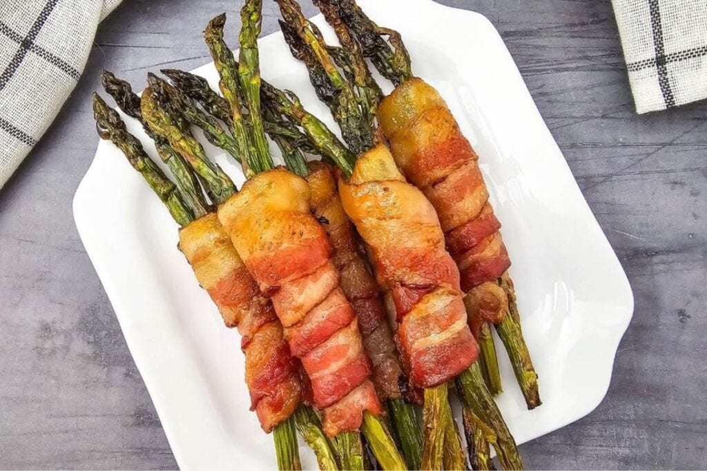 A close up shot of bacon wrapped asparagus.