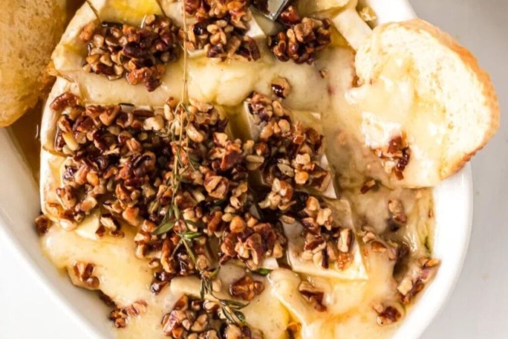 A close up shot of baked brie with toppings.