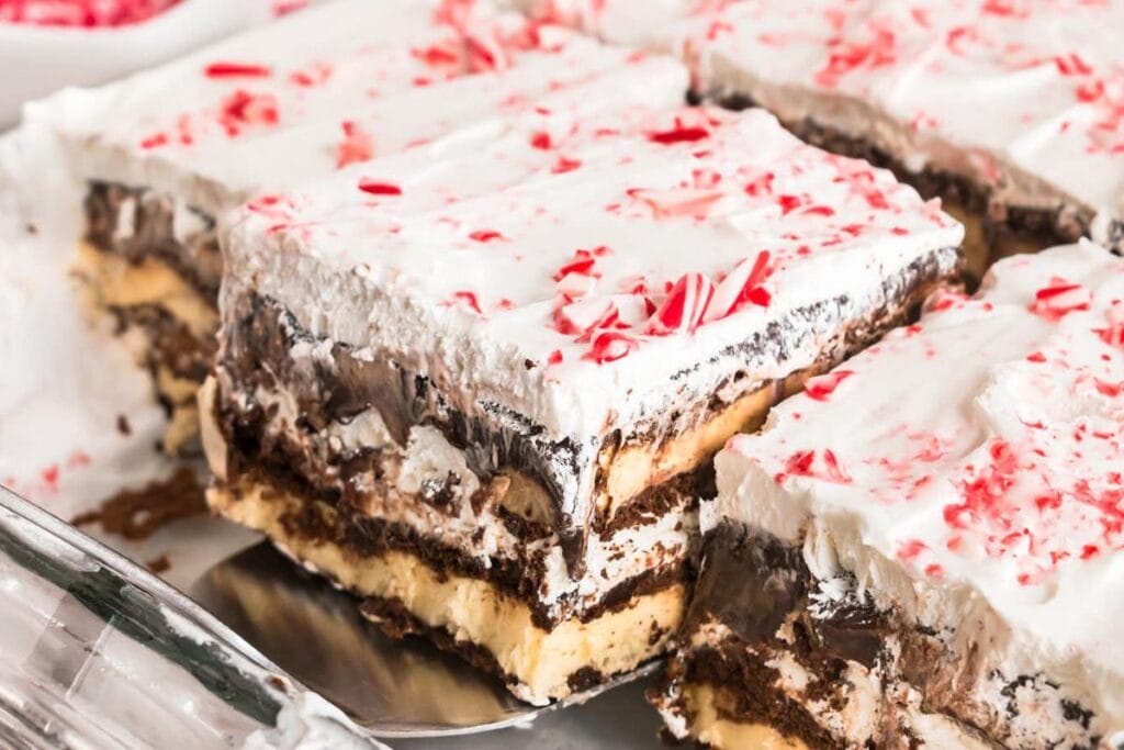 Slices of layered icebox cake with whipped cream and crushed candy canes.
