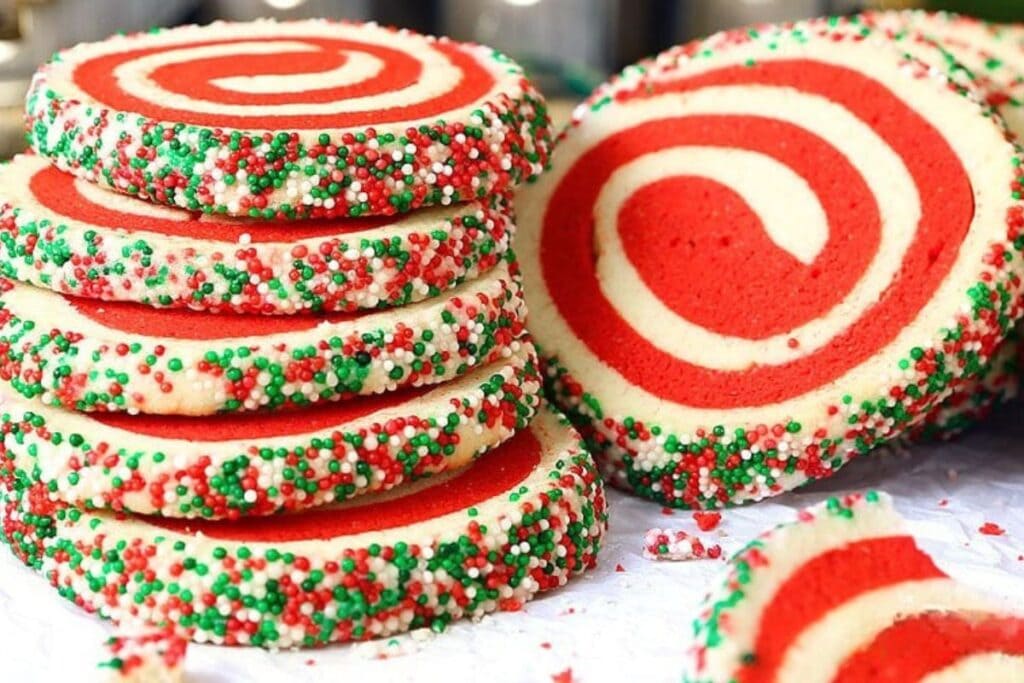 Red and white pinwheel cookies with sprinkles.