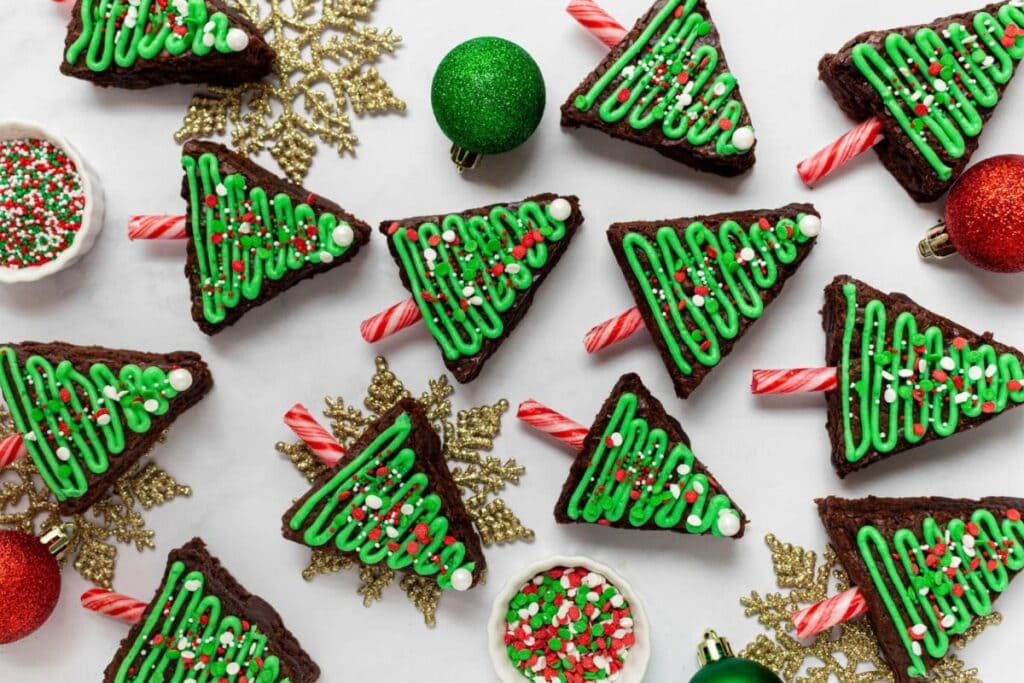 Overhead shot of Christmas tree brownies with candy cane trunks and sprinkles.
