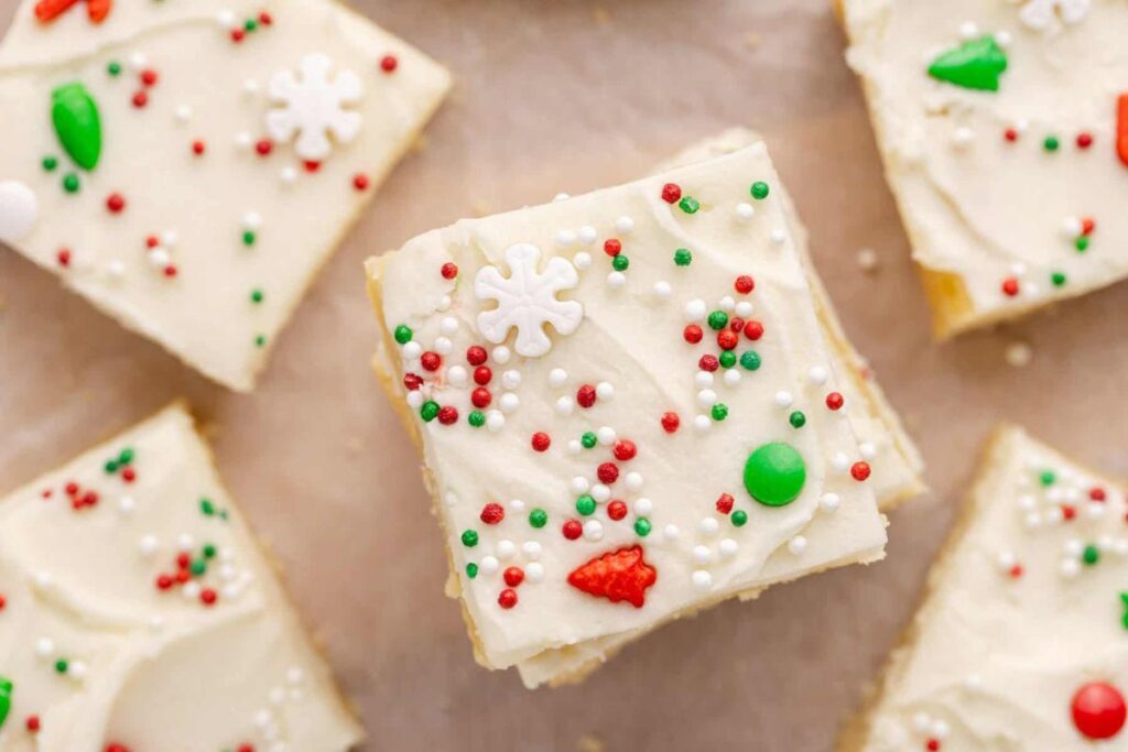 Overhead shot of sugar cookie bars with white frosting and Christmas sprinkles.