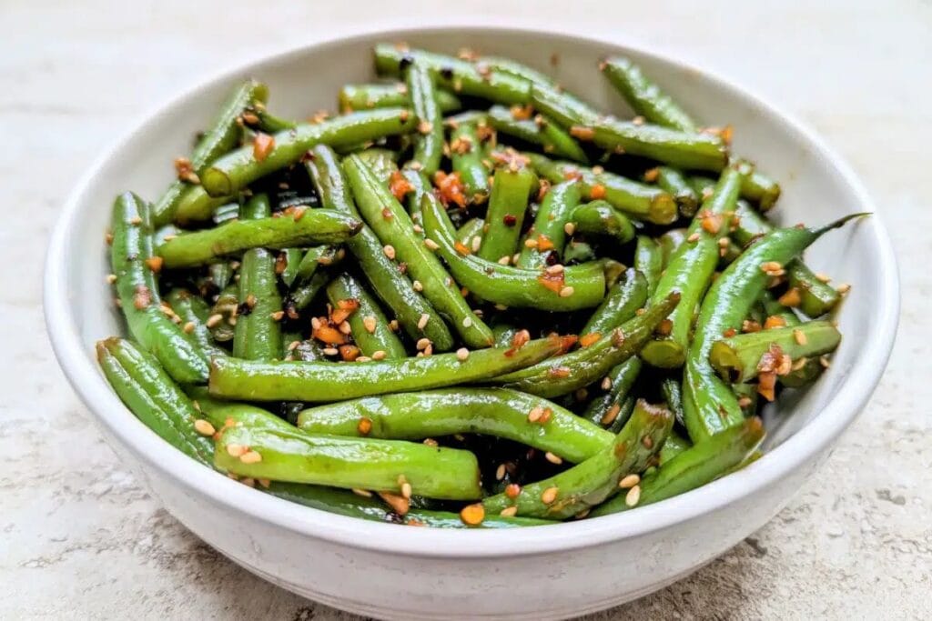 Garlic sesame green beans in a white bowl.