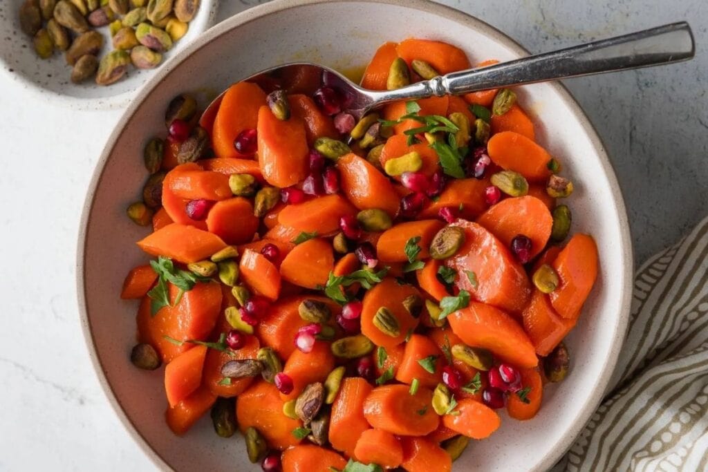 A close up shot of carrots with pistachios.