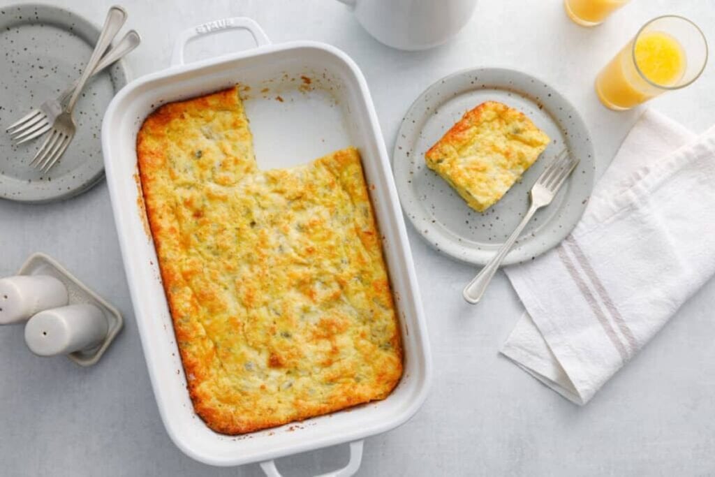 Overhead shot of a green chile egg casserole with a slice on a plate.
