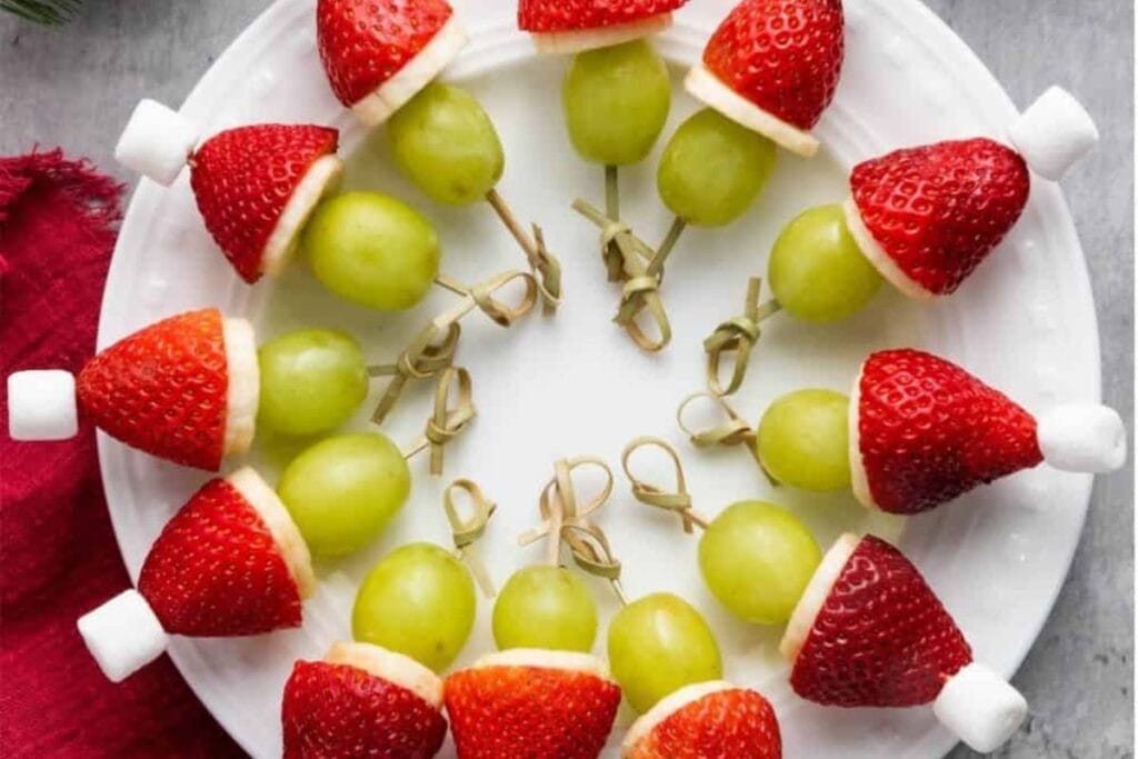 A close up shot of grinch fruit kabobs.