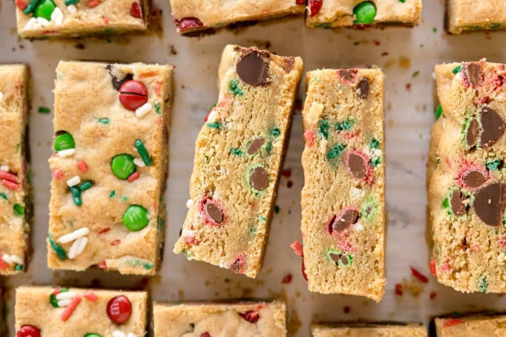 Overhead shot of M&M Christmas cookie bars with red, green, and white sprinkles.