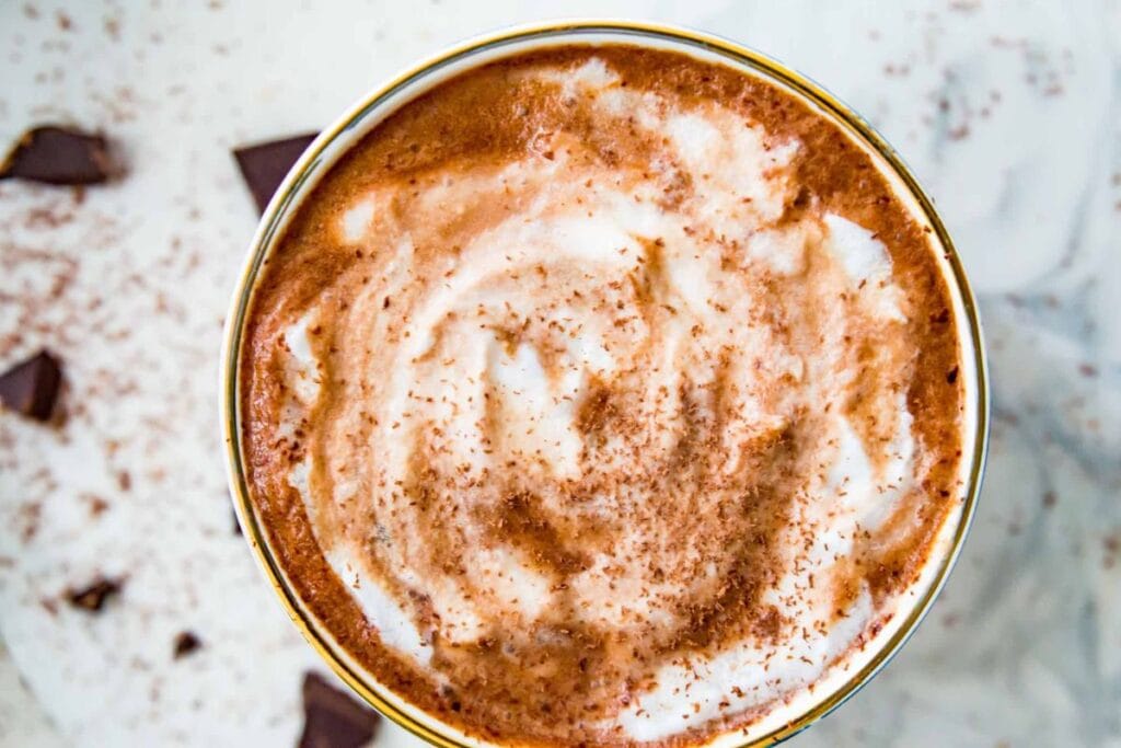 Overhead view of oat milk hot chocolate with chocolate shavings.