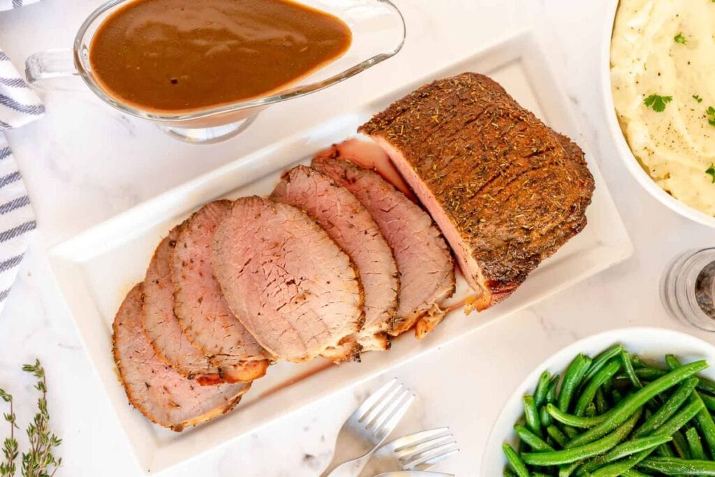 A close up shot of roast beef with gravy.
