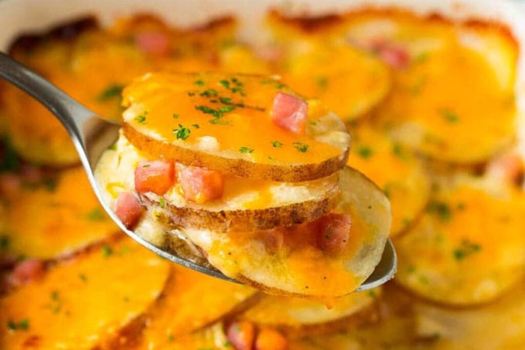 A close up shot of scalloped potatoes and ham.
