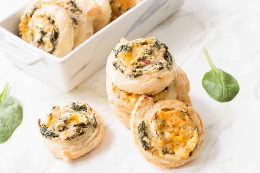 Bacon and spinach pinwheels on a plate.