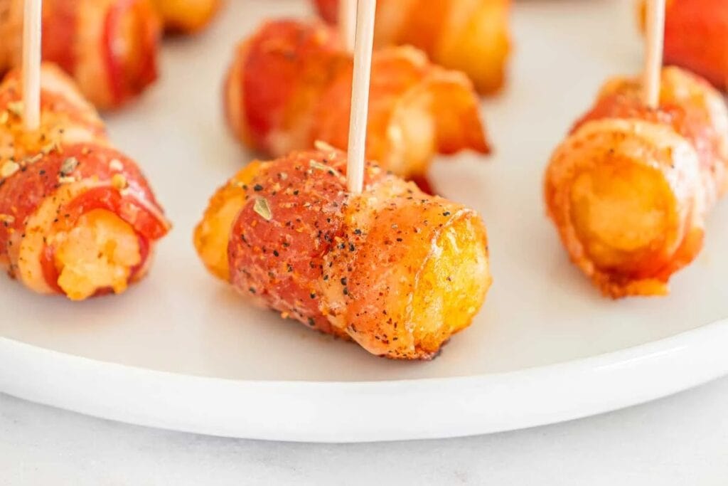 Bacon wrapped tater tots on a plate.
