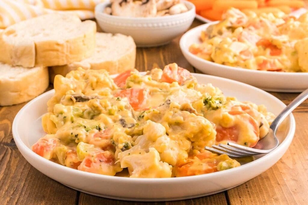Cheesy vegetable casserole on a white plate.