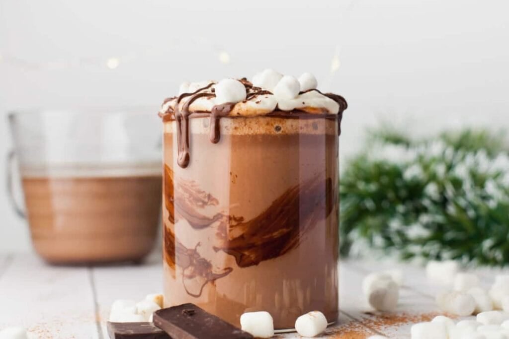 Hot chocolate in a glass topped with marshmallows.