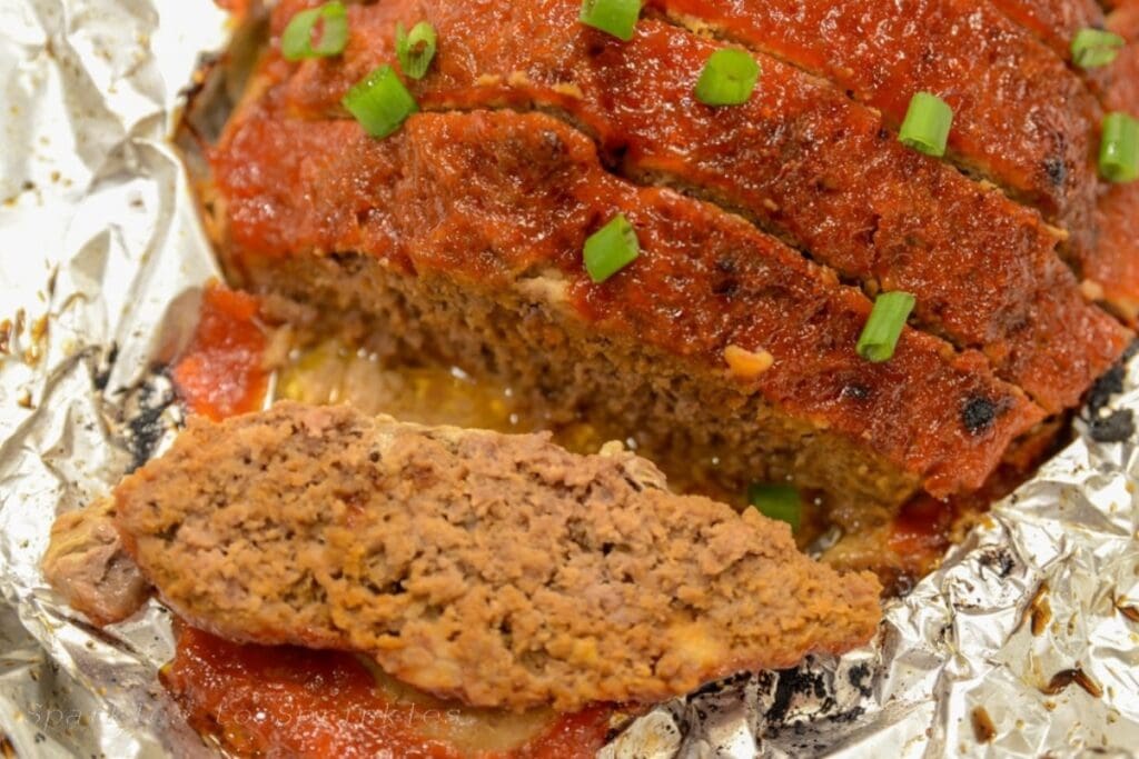 Sliced crockpot meatloaf on foil.