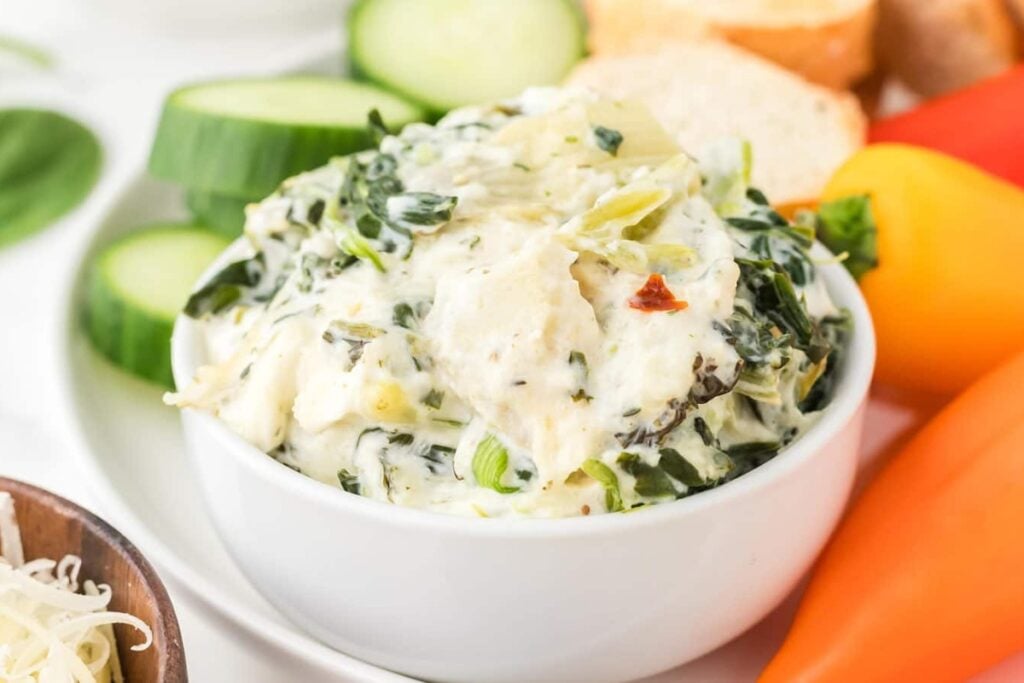 Close-up of creamy spinach artichoke dip in a bowl.