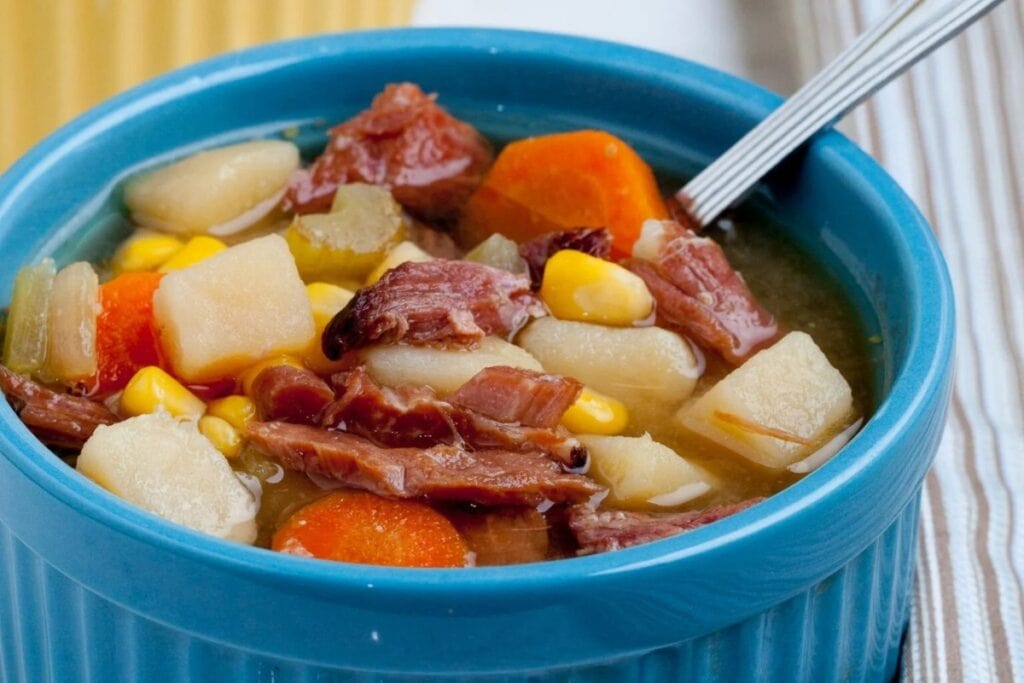 Ham potato vegetable soup served in a bowl.