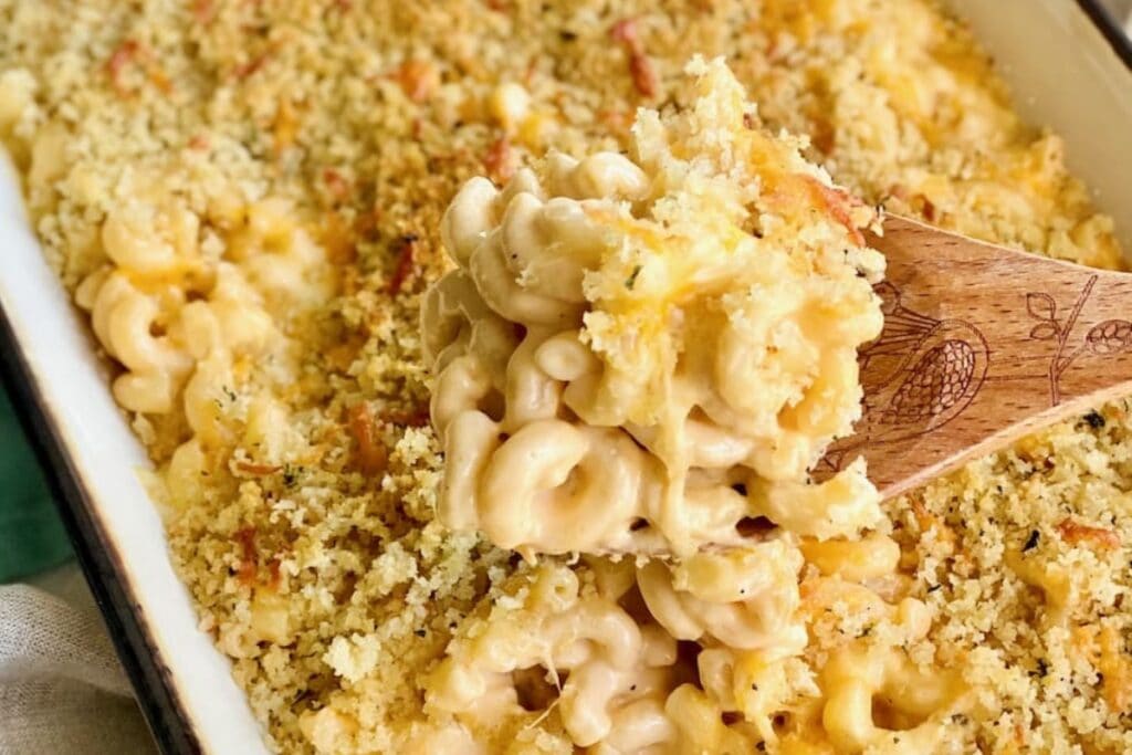 Close-up of homestyle mac and cheese on a wooden spoon.