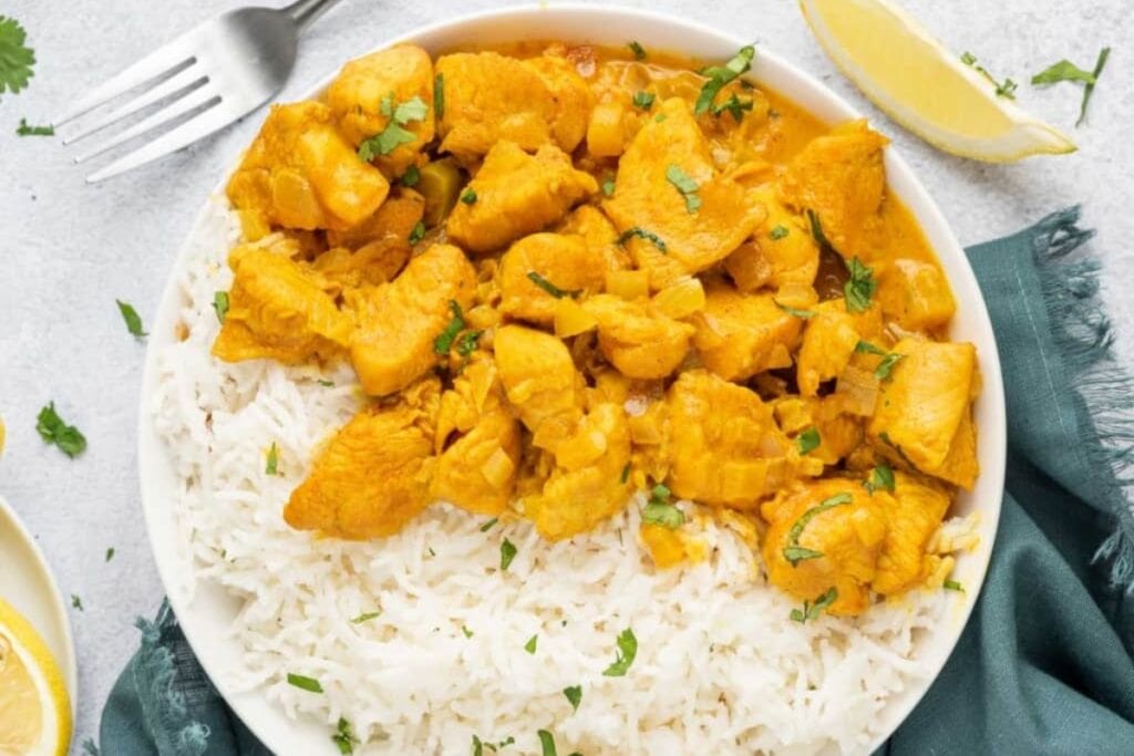 Plate of Indian chicken curry served with rice.