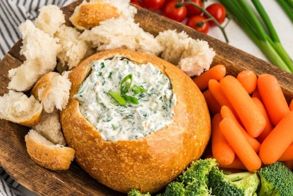 Creamy Knorr spinach dip served inside a hollowed-out bread bowl.