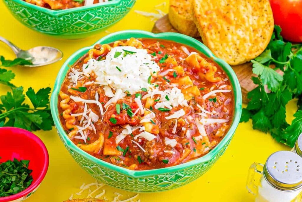 Lasagna soup in a bowl with noodles, sauce, and melted cheese.