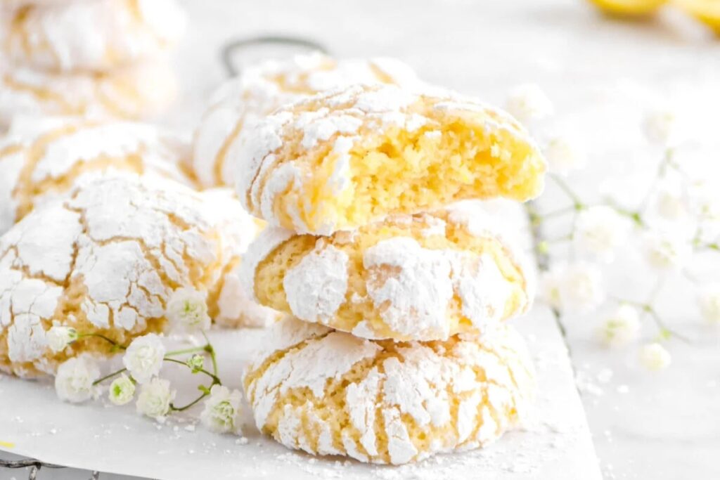 Stack of lemon crinkle cookies on a parchment paper.