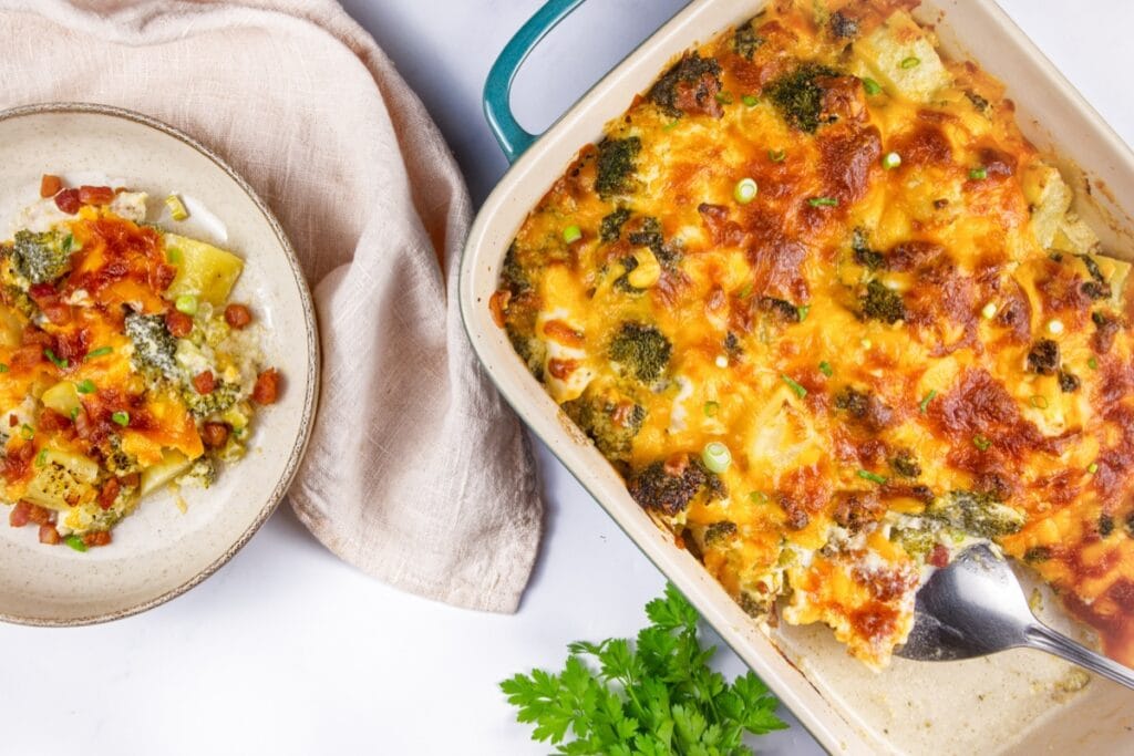 Top view of loaded cheesy chicken, broccoli, and potato casserole in a baking dish.
