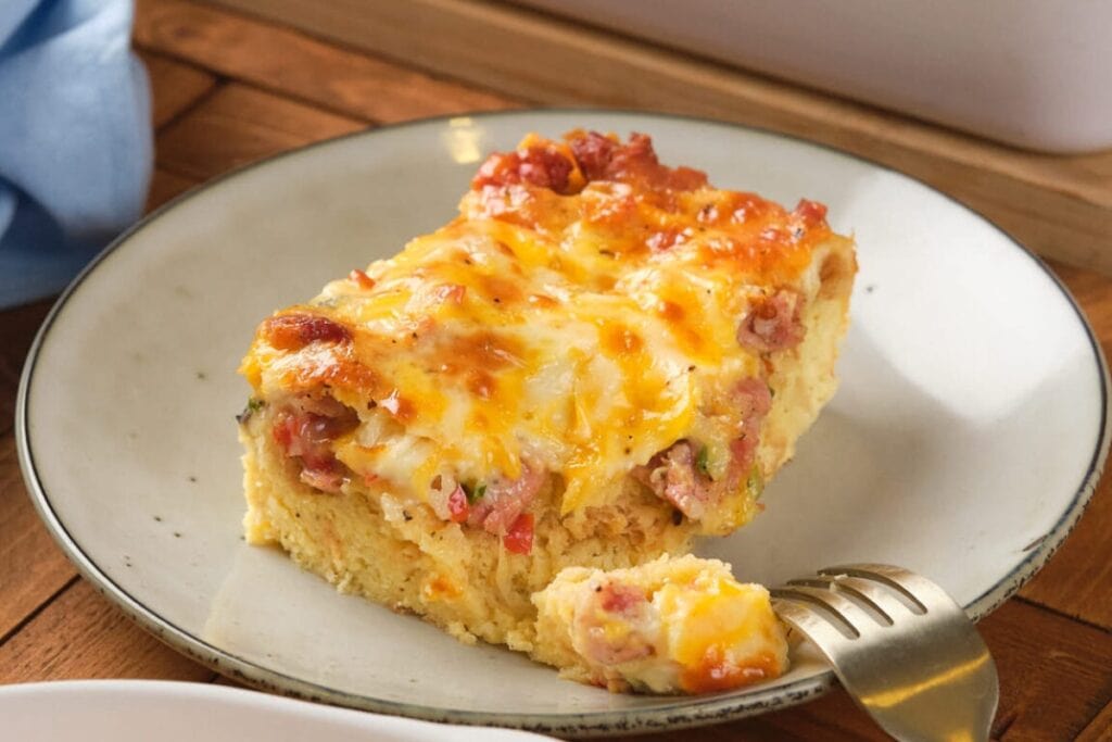 Slice of overnight breakfast casserole on a plate.