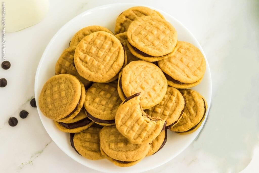 Peanut butter cookie sandwiches on a white plate.