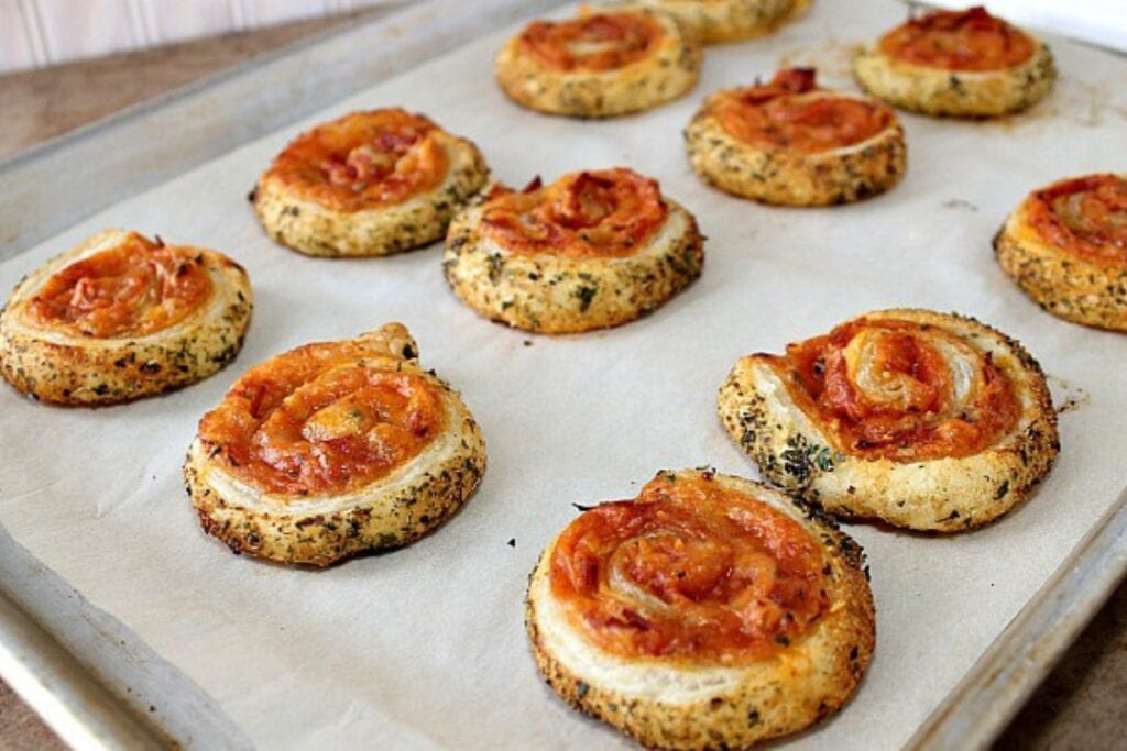 Puff pastry pizza wheels on a sheet pan.