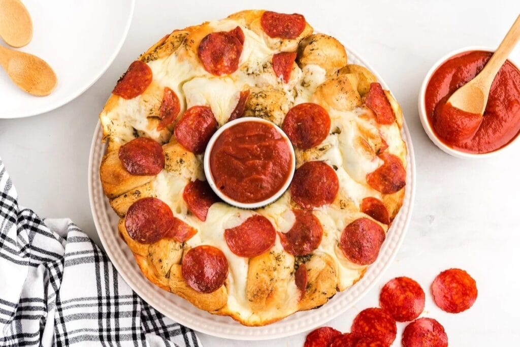 Pull-apart pizza bread with pepperoni on a plate.
