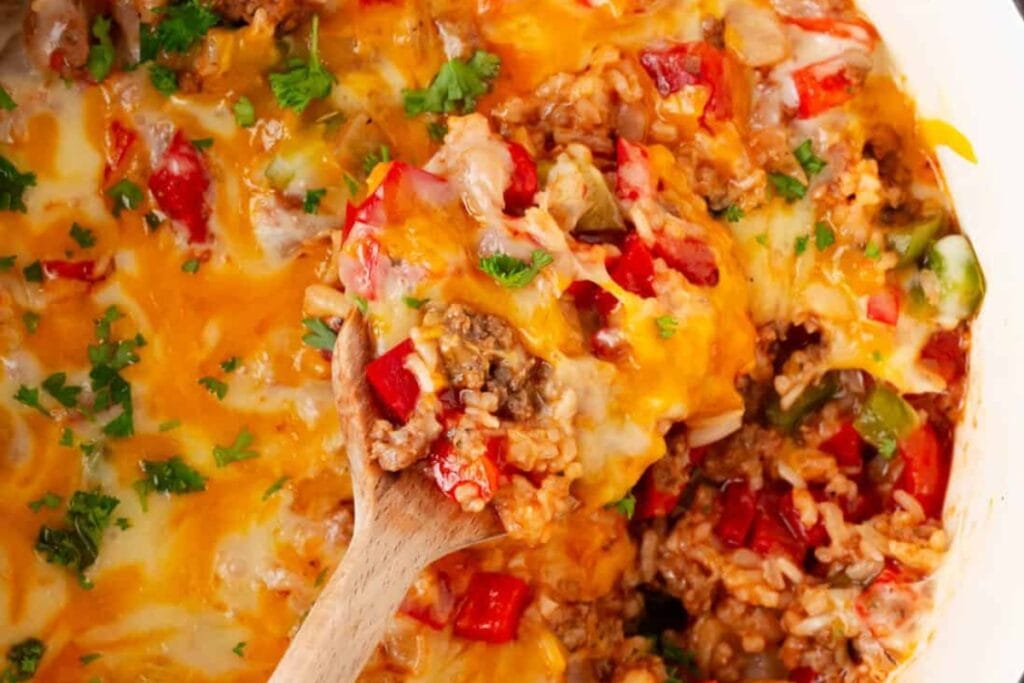 Stuffed pepper casserole scooped with a wooden spoon.