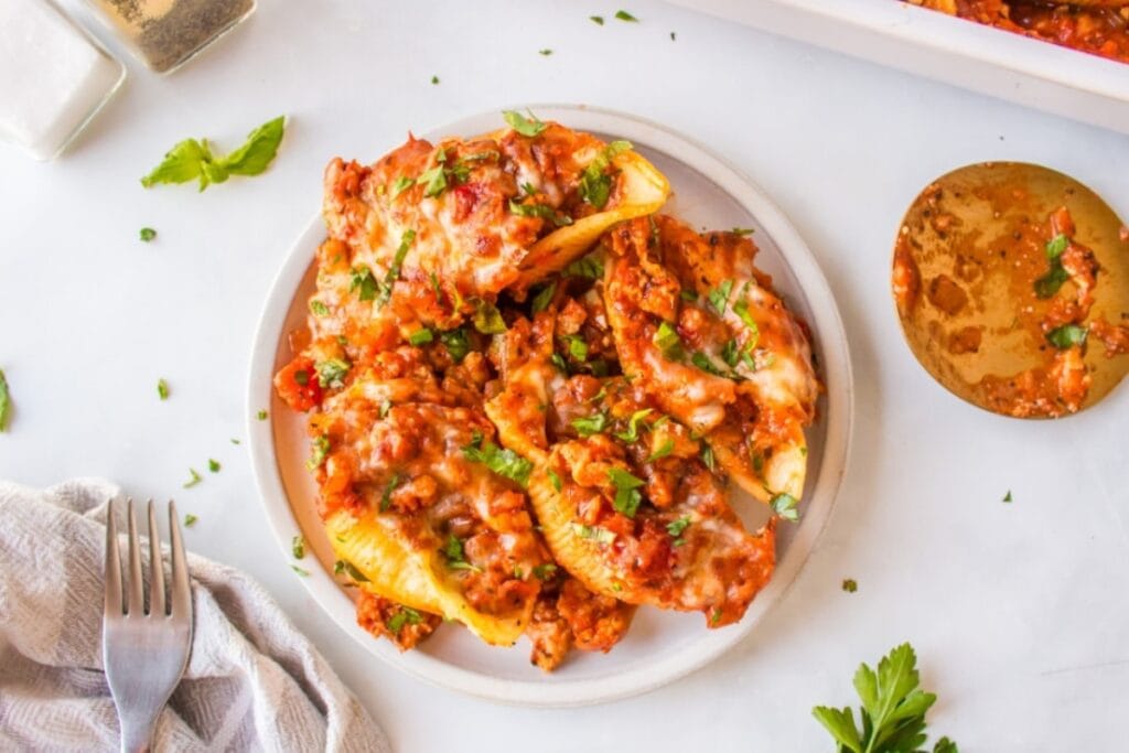 Stuffed shells with sausage on a plate.