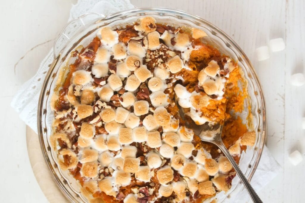 Sweet potato casserole topped with marshmallows in a glass baking dish.