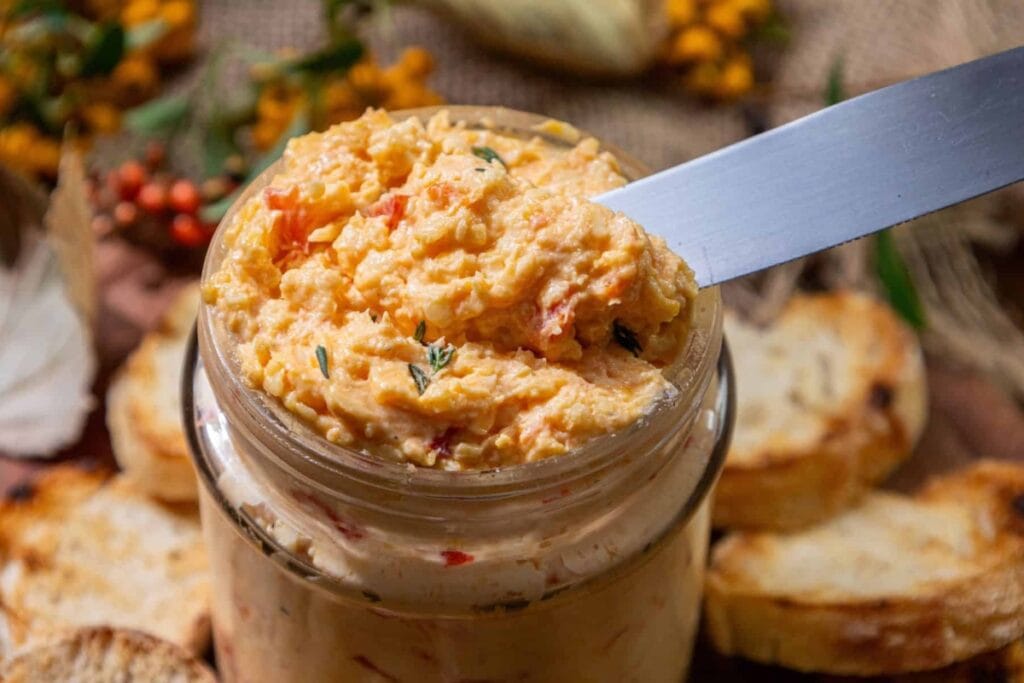 White cheddar pimento cheese in a jar.