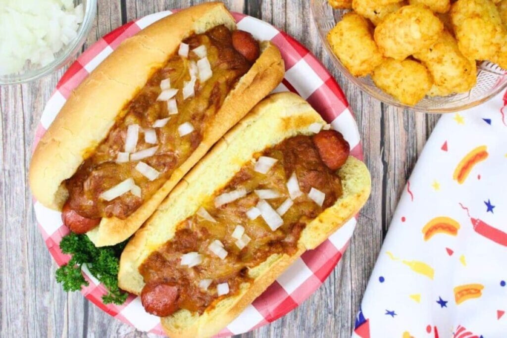 Two chili cheese dogs with onions, served with tater tots.
