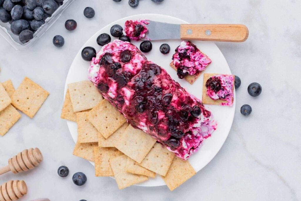 Goat cheese log with blueberry sauce and crackers.