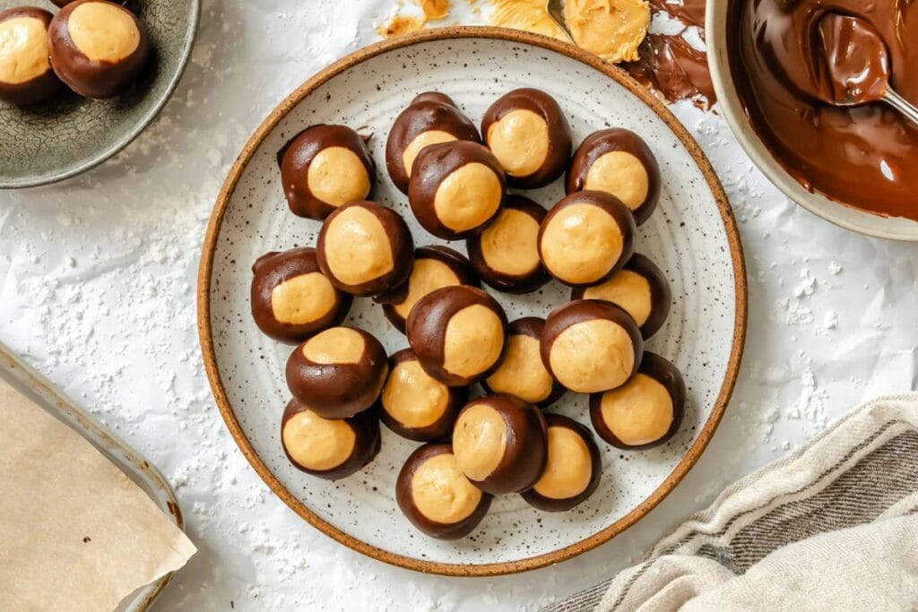 Overhead shot of buckeyes candy on a plate, with melted chocolate.