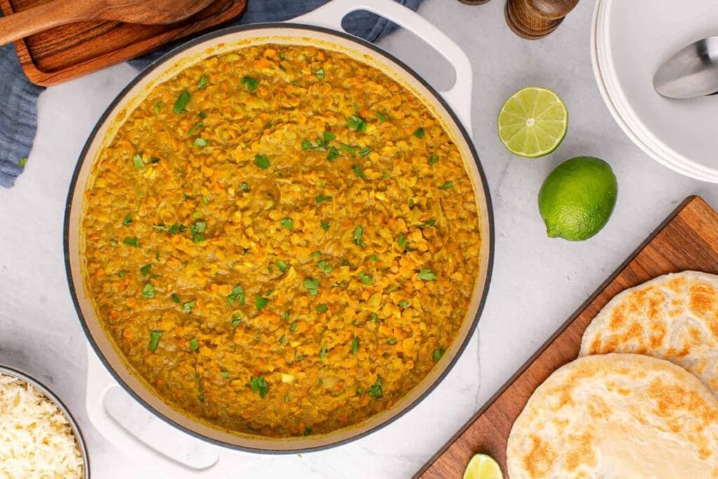 Overhead shot of coconut milk curry lentils with naan bread and rice.